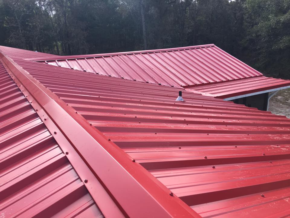 Top view of residential home with red color metal roof panels.